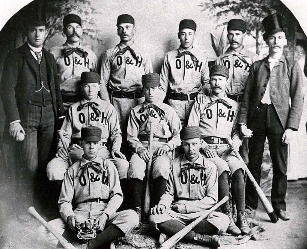 Antique photo with nine baseball players and two coaches.